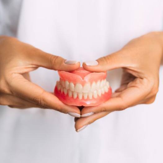 Lady presents viewer with dentures