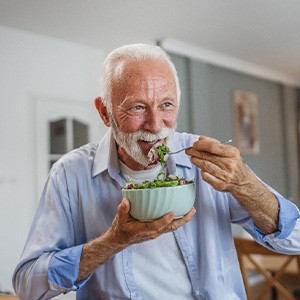 Man smiling while eating lunch at home