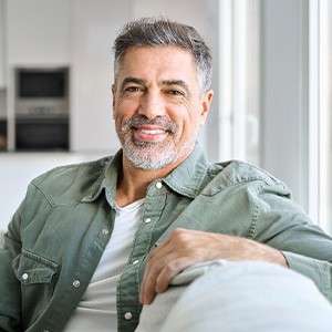 Man smiling while relaxing on couch at home