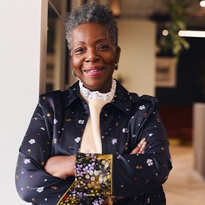 Woman in black blazer smiling in office