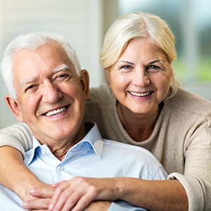 an older couple with dental implants smiling