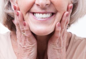 Older woman with dentures smiling.